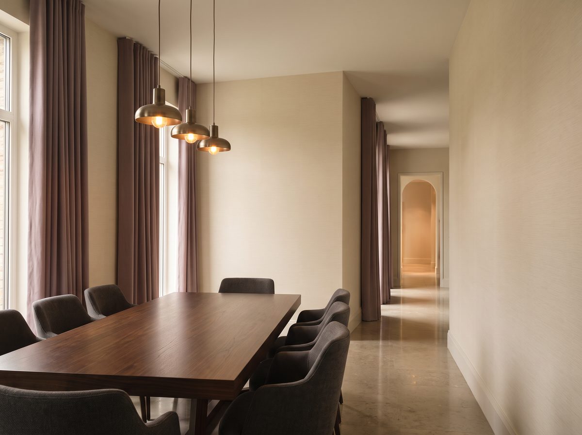 Dining room or hallway with warm ivory wallcovering and brushed bronze lighting